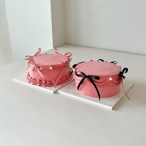 ピンクのクリームにリボンをあしらったホールケーキ